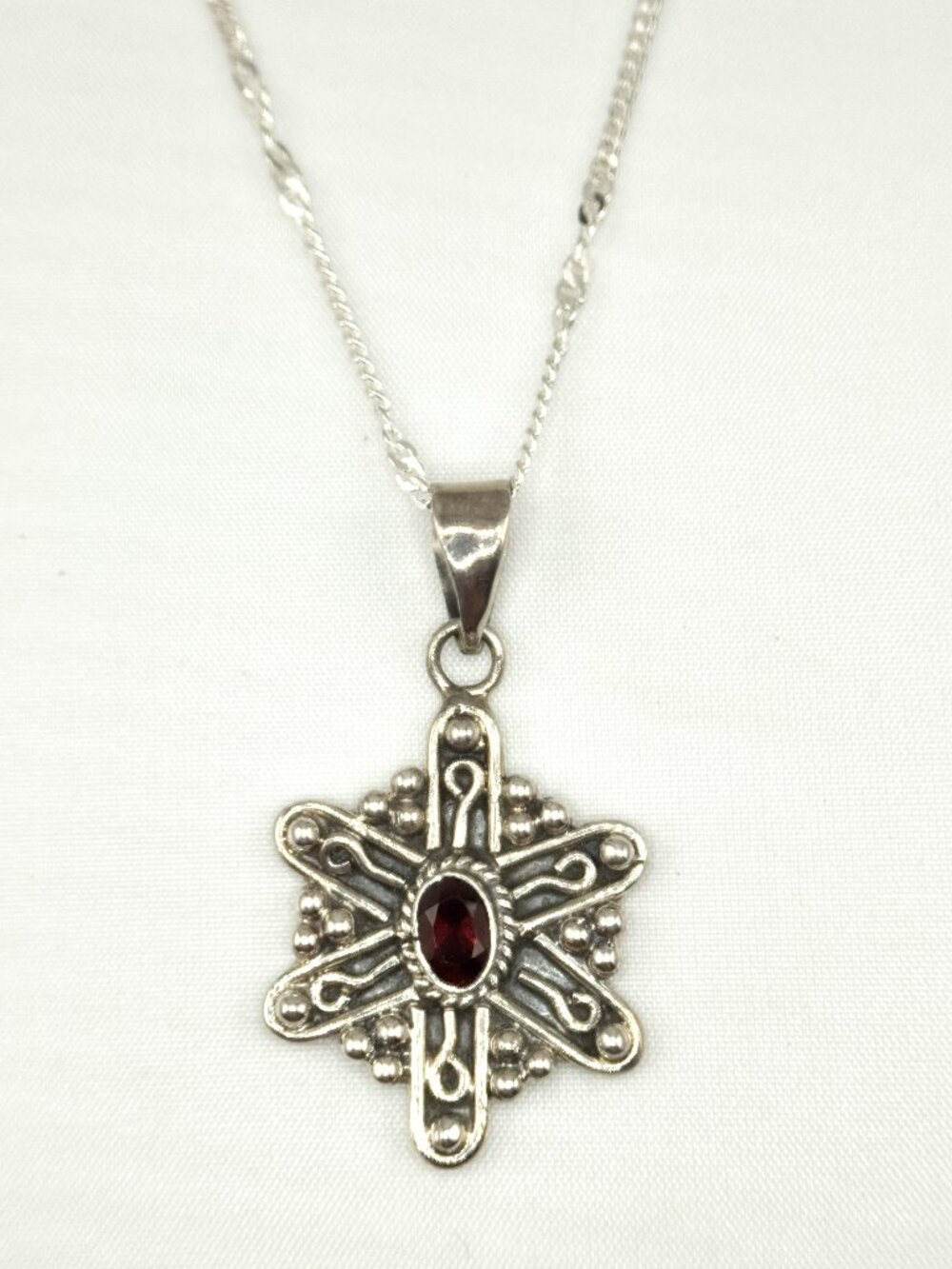 Sterling silver necklace with snowflake style pendant, oval Garnet, NWOT